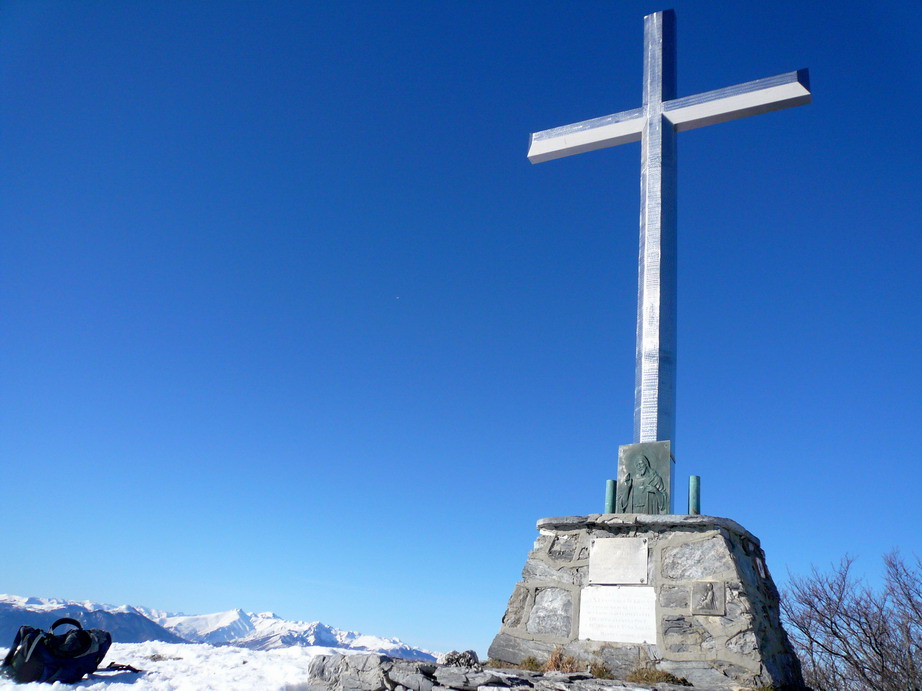 La croce, da sola, con lo sfondo delle Alpi Liguri che scintillano al sole bianche di neve.