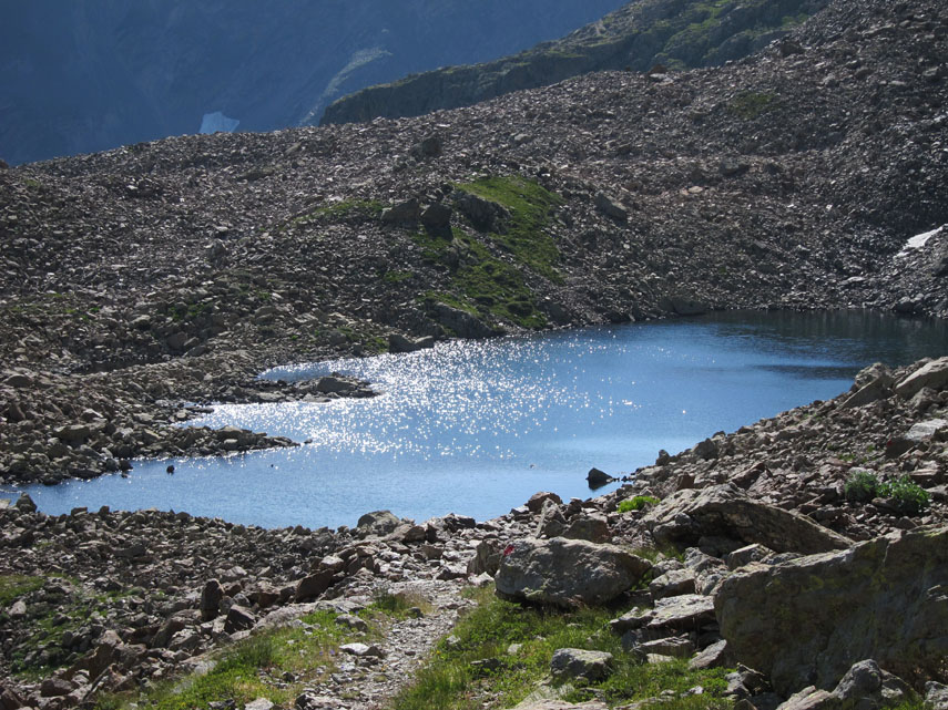 Quasi al termine della pietraia un grazioso specchio d'acqua scintilla ai raggi del sole: è il piccolo Lago Mongioie
