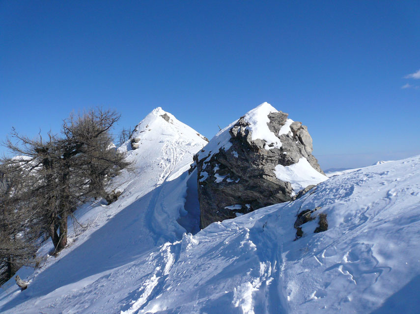 La cresta procede in direzione nord-est, affilata e a tratti esposta, verso il Pian Camozzera e la vetta del Monte Fantino