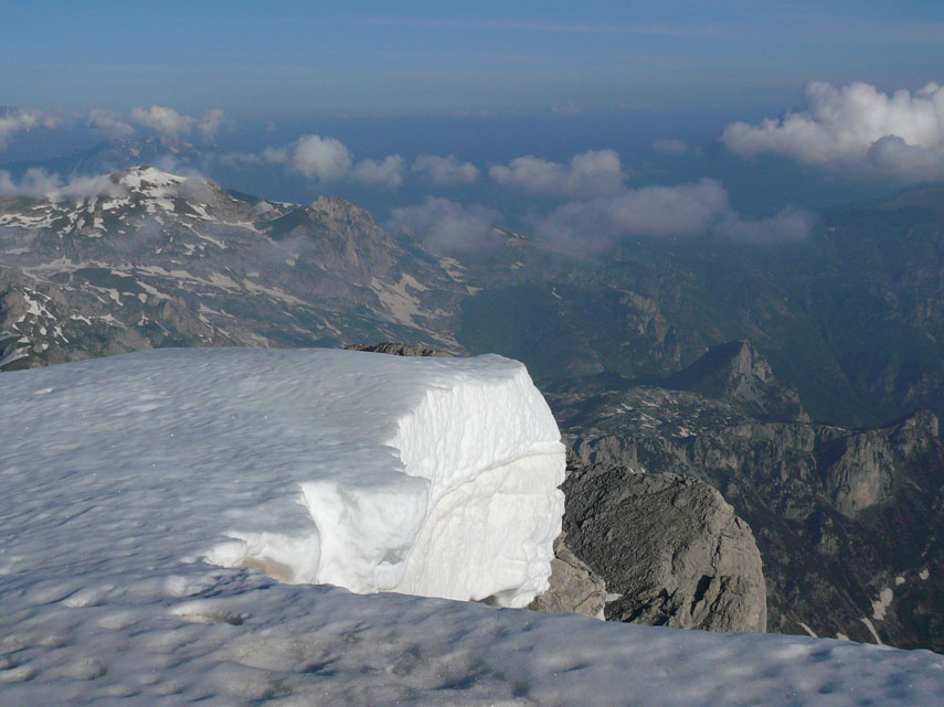 Grosse cornici di neve orlano la poderosa bastionata calcarea sul lato della Valle Pesio