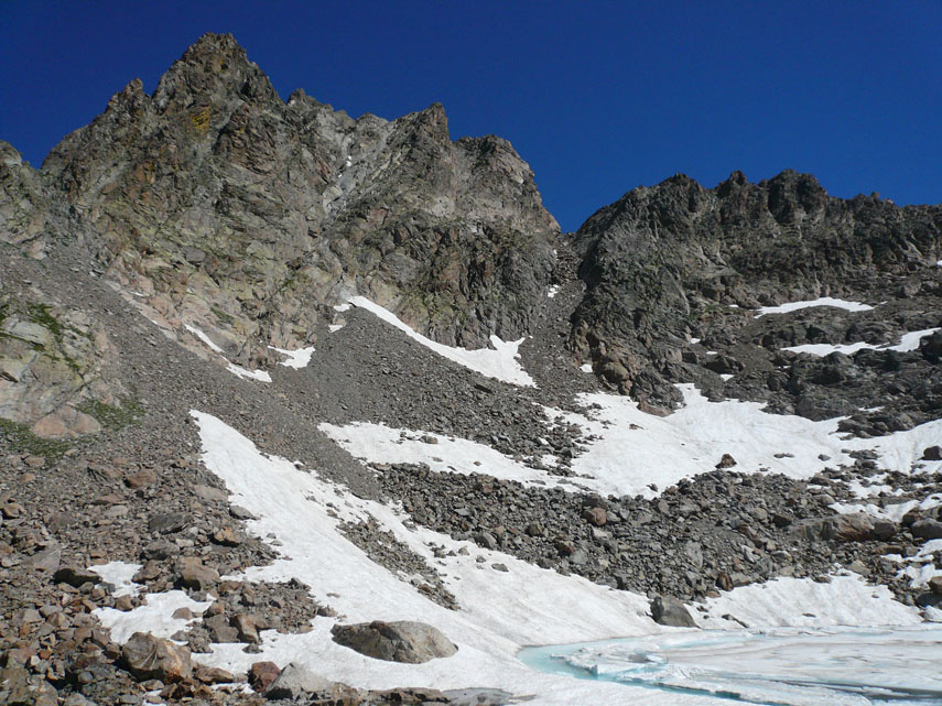 A passo spedito raggiungo velocemente il Lago della Nasta (mt. 2800), ancora coperto di ghiaccio e neve, …
