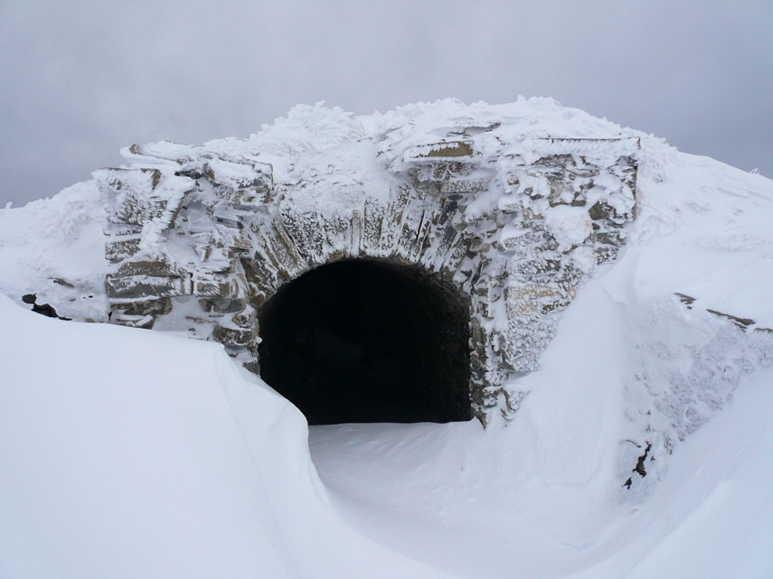 Tra la neve spuntano ancora le riservette in caverna per i quattro cannoni installati a ridosso della cresta nel 1900