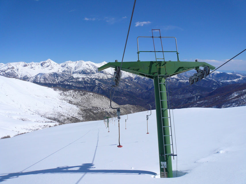 ... scendo lungo la pista da sci fino al cartello di confine delle due province (Cuneo e Imperia). I piloni dello skilift sembrano nani e i piattelli sfiorano la neve!