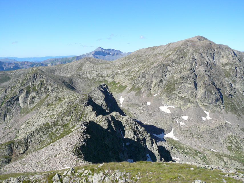 La cresta prosegue frastagliata in direzione sud fino a saldarsi con la displuviale Stura-Tinea sopra il Colle della Seccia; in alto a destra la Cima di Collalunga e, al centro sullo sfondo, il Monte Mounier