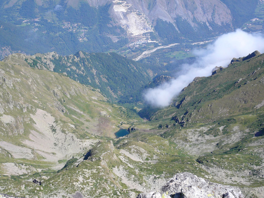 ... mentre novecento metri più in basso si scorge il piccolo Lago di Lausetto racchiuso tra la Serra del Lausetto (a sinistra) e il Monte Ray (a destra)