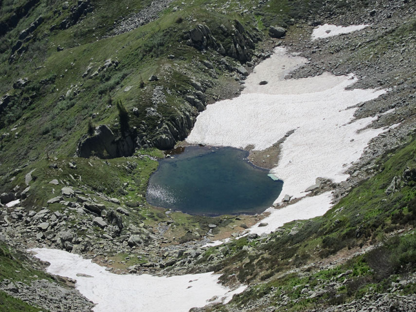 Quattrocento metri più in basso, adagiato in una piccola conca sospesa tra la Costa Valcaira e la displuviale Armella-Corsaglia, luccica il piccolo Lago del Pizzo tra residue lingue di neve in rapido scioglimento