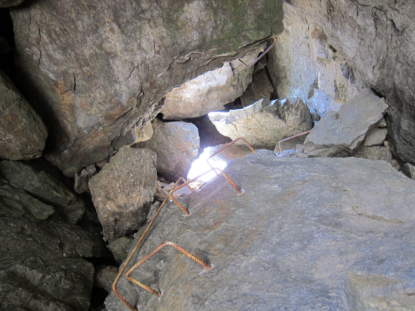 Alcune staffe di ferro, in verità non particolarmente comode ed eccessivamente distanziate tra di loro, permettono di guadagnare lo sbocco superiore della grotta (un po' di esposizione in uscita) e il soprastante Passo della Marmotta (m. 2900)