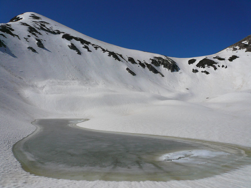 Una pozza d’acqua ghiacciata raccolta tra distese di neve immacolata rende ancor più suggestivo questo piccolo anfiteatro
