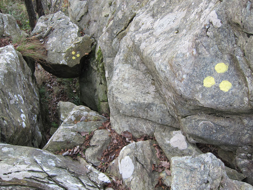 Si incontra dapprima una sorta di “sottopasso” creato da un macigno incuneato tra due rocce: occorre quasi strisciare al suo interno per poi uscirne con facile arrampicata (difficoltà EE/F)