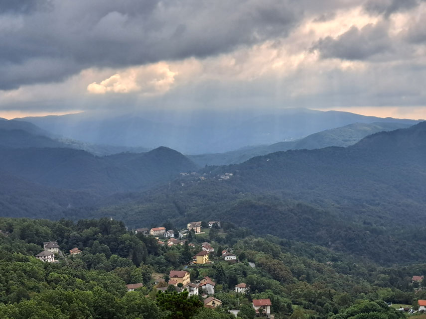 Nuvole scure che oggi nascondono il crinale del Beigua, la pianura padana e le Alpi ci offrono però una bel panorama sulla valle dell’Orba e una veduta aerea sulle case di Tiglieto